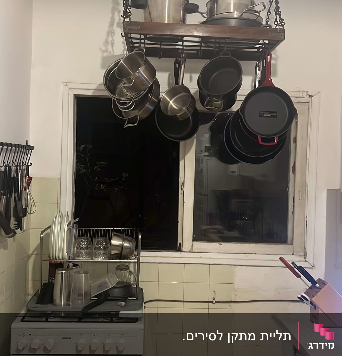 מדף תלוי עם סירים ומחבתות במטבח